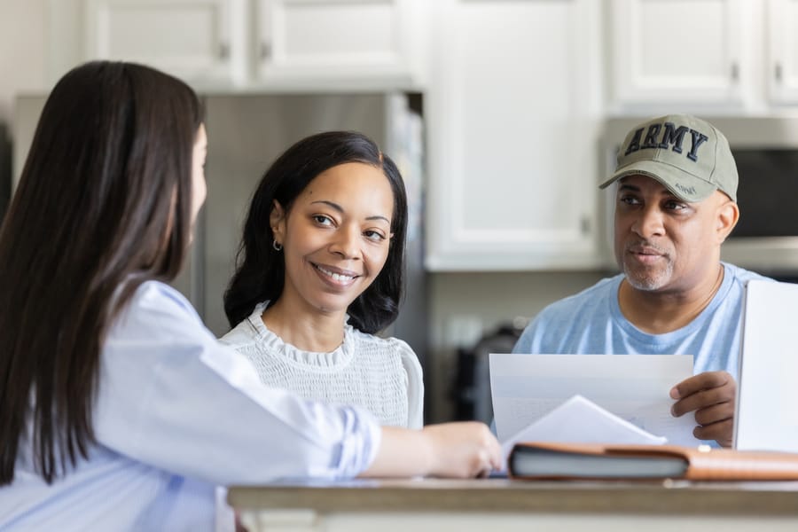 Homeowners reviewing insurance claim paperwork with roofing consultant.